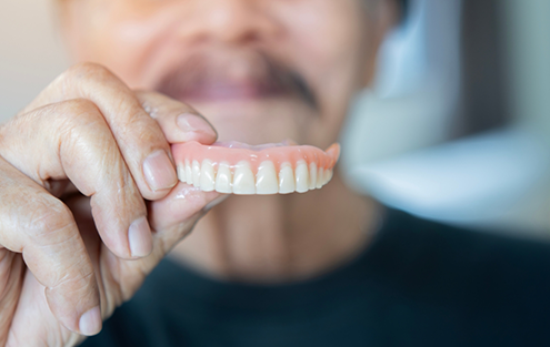 Man holding a full denture