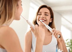 Woman using electric toothbrush