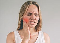Woman in pain holding her cheek