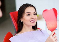 Woman looking at her smile in the mirror