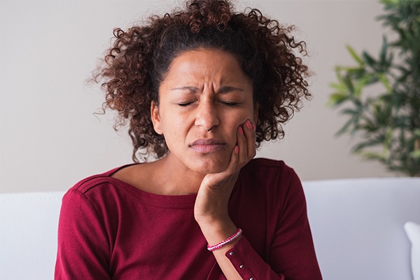 Woman holding cheek in pain