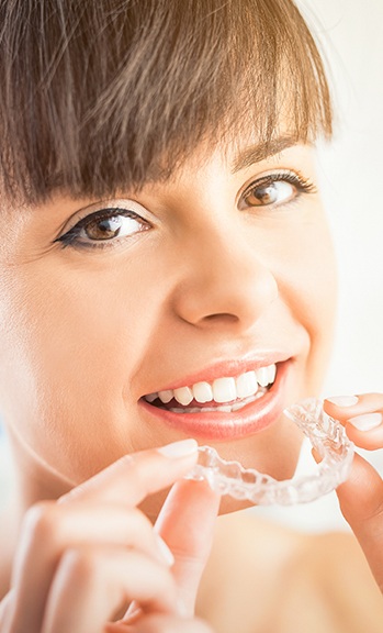 Woman placing Invisalign tray