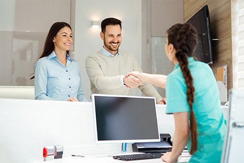 couple shaking hands at reception desk