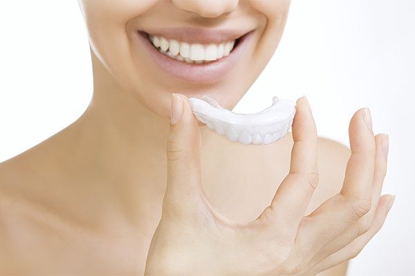 woman holding invisalign