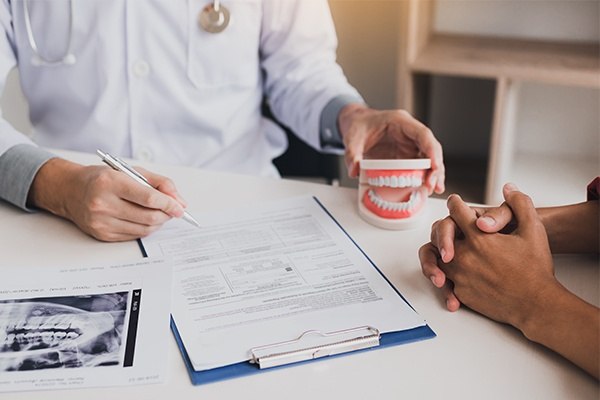 Dentist and patient reviewing dental insurance forms