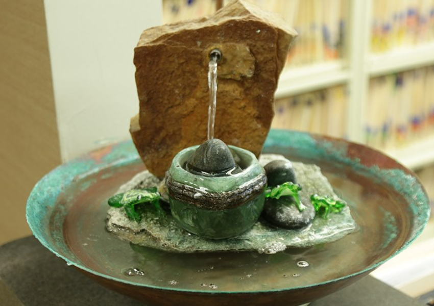 Figurine of waterfall over rocks on a plate in dental office