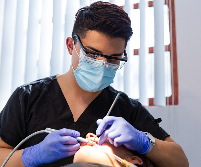 Dentist performing an oral cancer screening on a Torrance dental patient