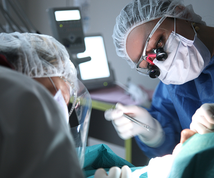 Dentist performing an oral surgery procedure on a patient