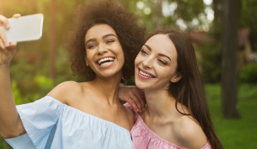 Two young women taking a selfie together outdoors