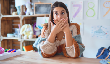 Woman covering her mouth with her hands and looking surprised