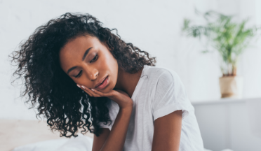 Woman wincing and holding the side of her jaw in pain