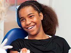 Smiling young woman in dental chair for children's dentistry