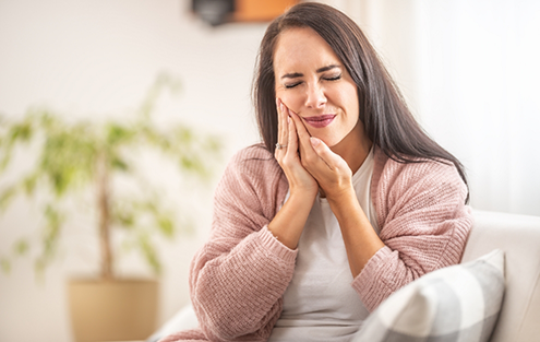 Woman holding the side of her face in pain