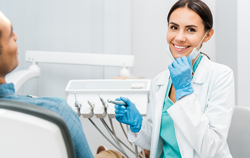 Dentist smiling while seeing a patient