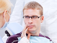 Man holding jaw in pain before root canal therapy
