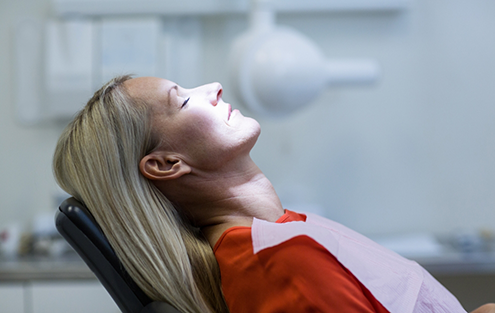 Woman in dental chair with eyes closed