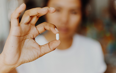 Person holding a white pill