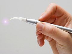 Hand holding a soft tissue laser dentistry tool