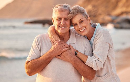 Smiling senior couple enjoying time on the beach