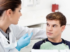 A dentist talking to a male patient