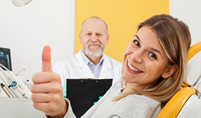 Woman giving thumbs up in dental chair