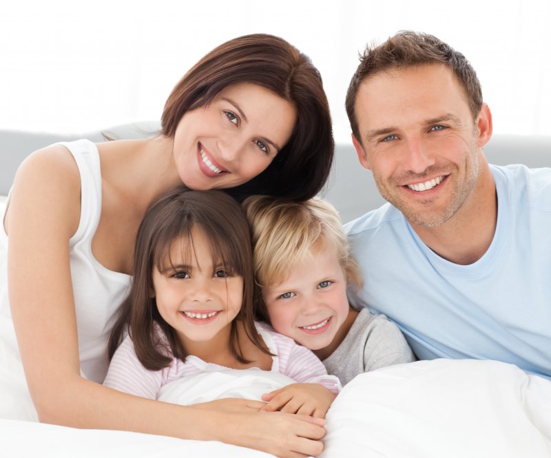 family of four hugging and smiling