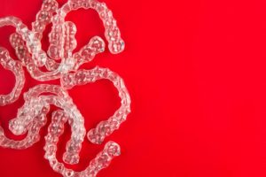 Invisalign clear aligners on red background