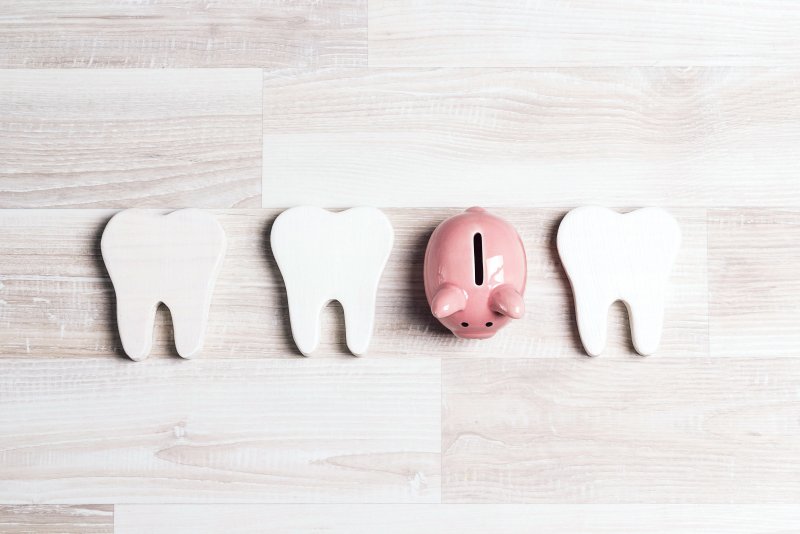 Piggy bank in a row of cardboard teeth