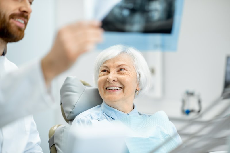 Dentist showing smiling woman her X-rays