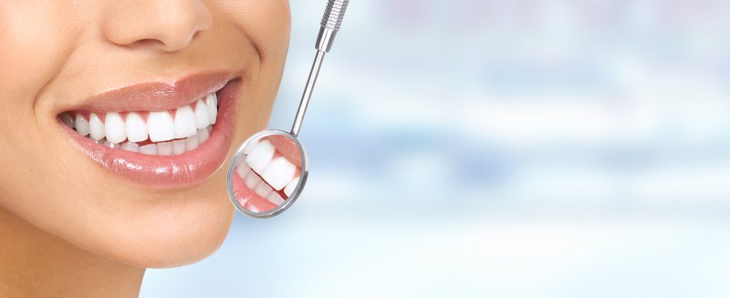 an up-close view of a person’s teeth and a dental mirror in Torrance