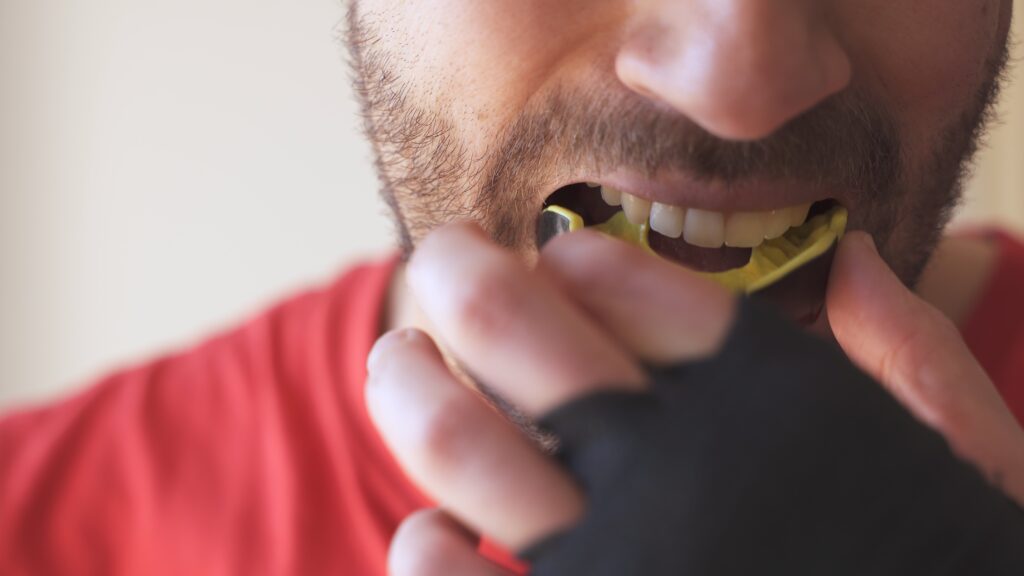 Patient putting in a new mouthguard
