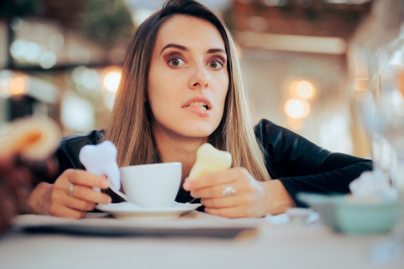 woman with a cup of coffee looking unsure