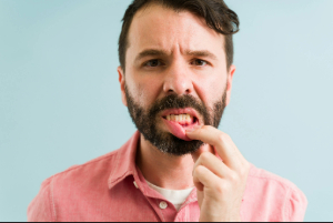 Concerned man pulling down his lip to show signs of gum disease