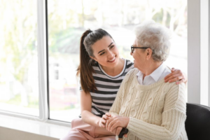 Woman talking with a senior patient in front of a grand window